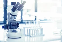 Hidroponik sistemlerde E. coli riski araştırmasını temsil eden laboratuvar mikroskobu ve test tüpleri